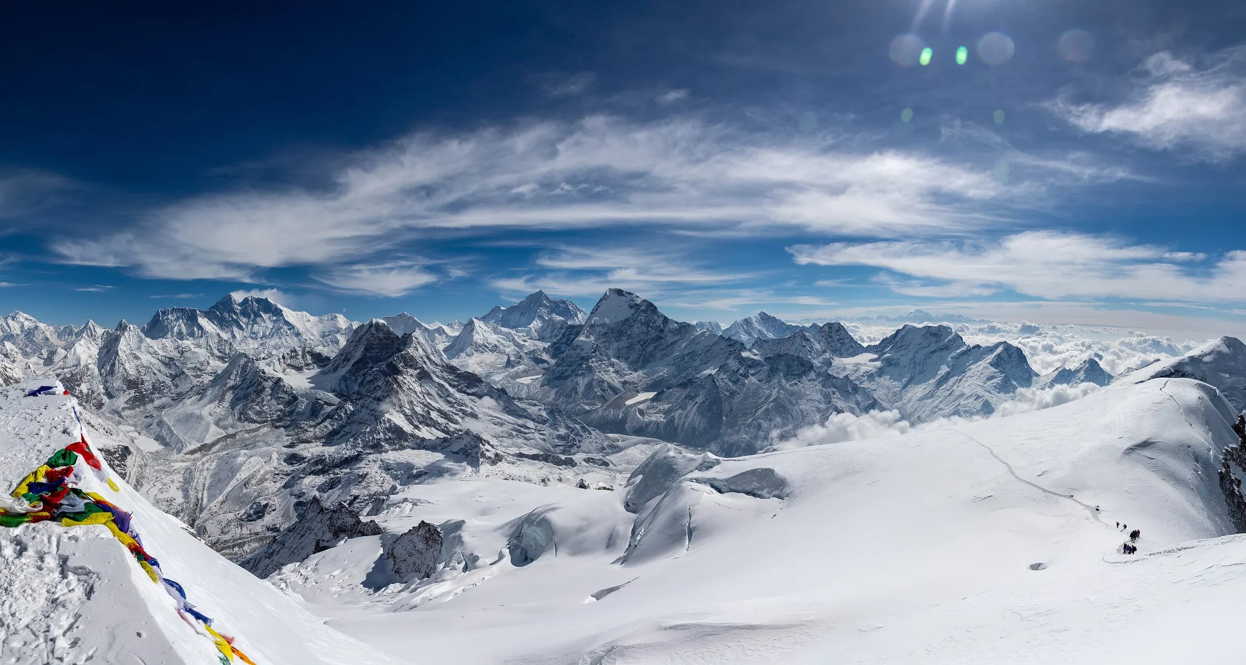 Climbers crossing the high snowfields of Mera Peak with the Himalayan range on the horizon