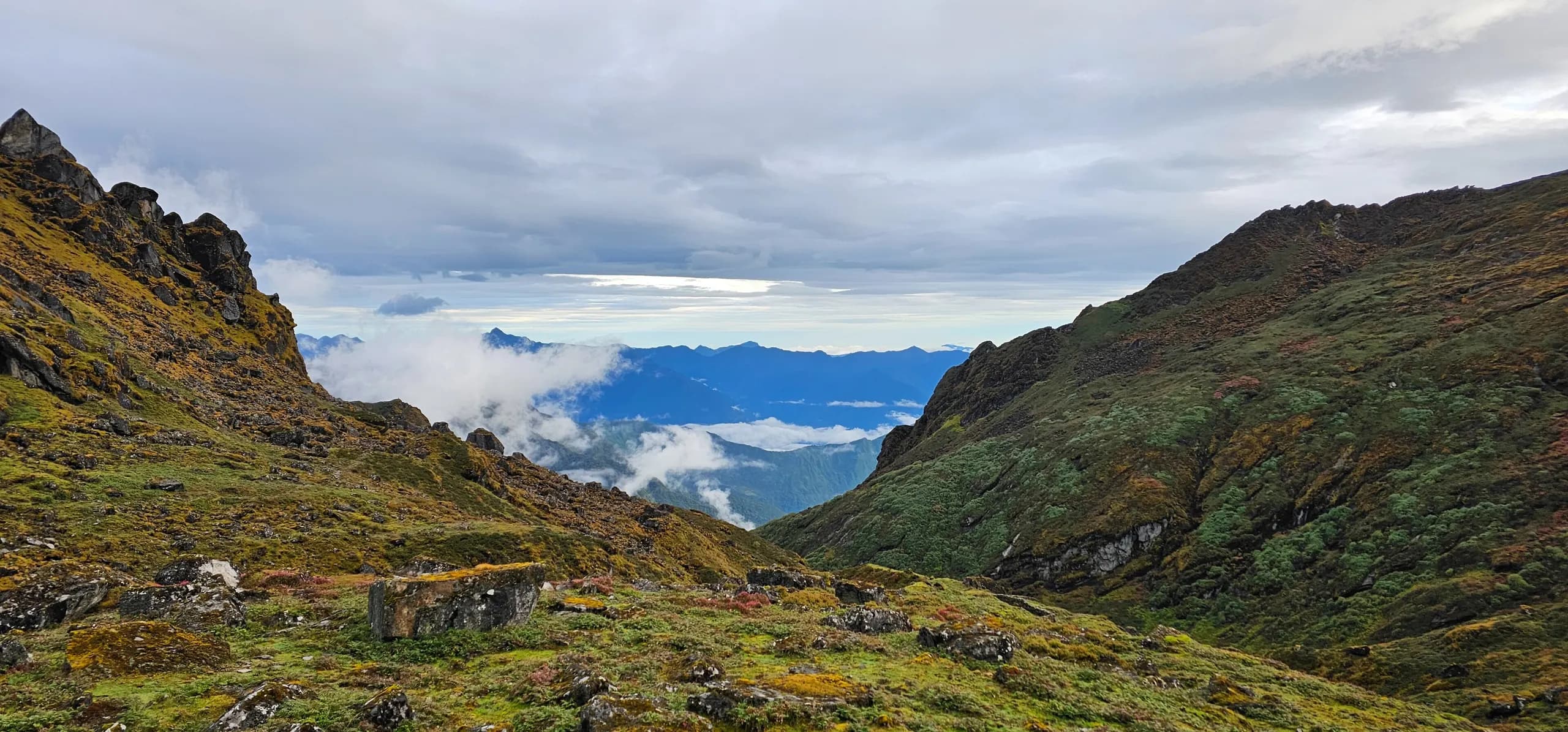 View from a high pass on the Mera Peak approach over layered blue ridgelines